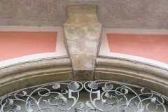 rzeźbiony zwierz, kuta krata i dolna część balkonu